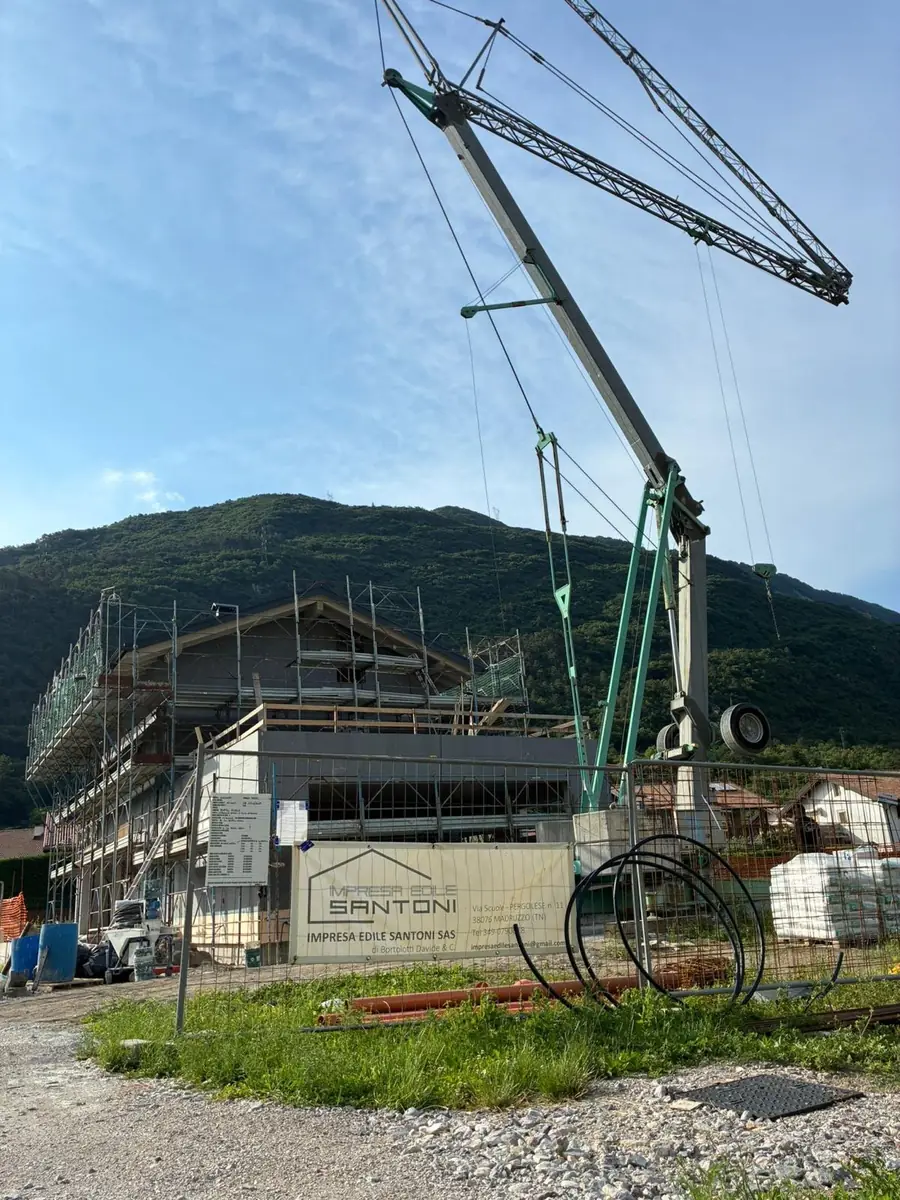 Cantiere di una nuova palazzina con gru e cartello Impresa Edile Santoni