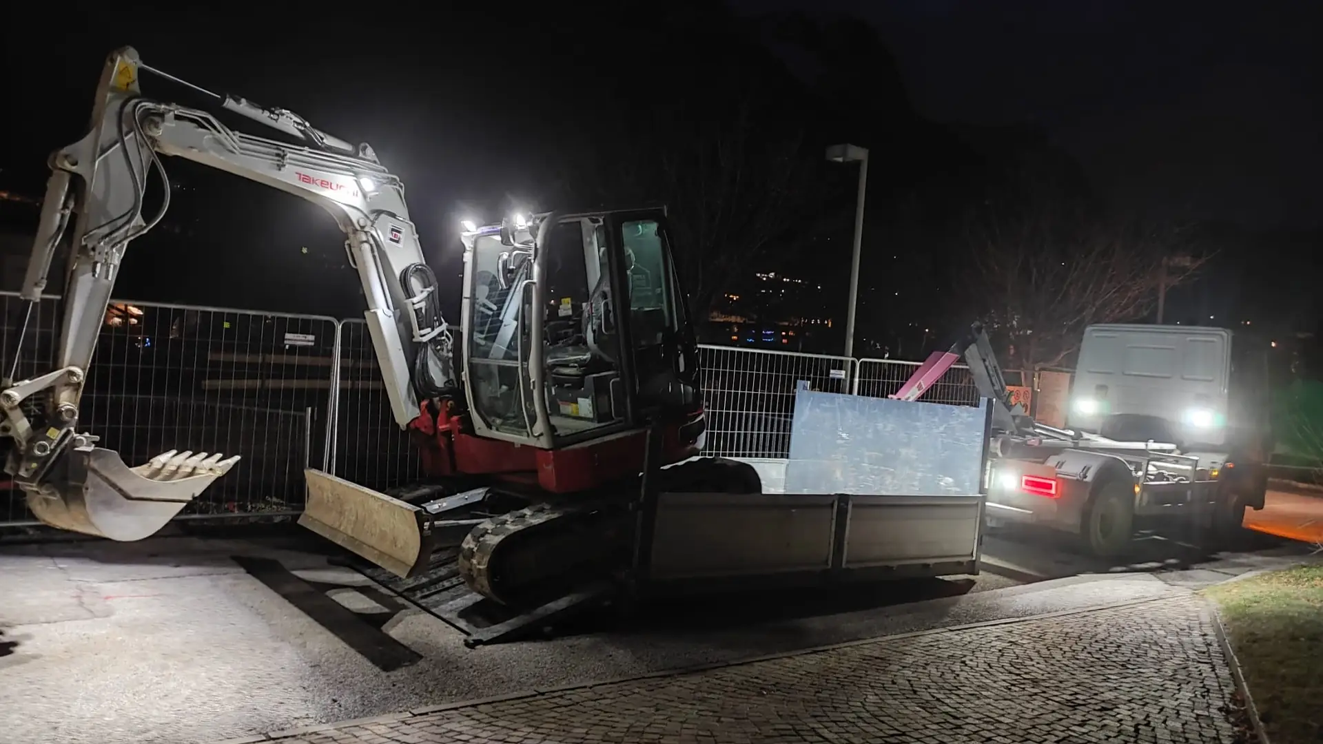 Escavatore dell'Impresa Edile Santoni al lavoro di sera in un cantiere