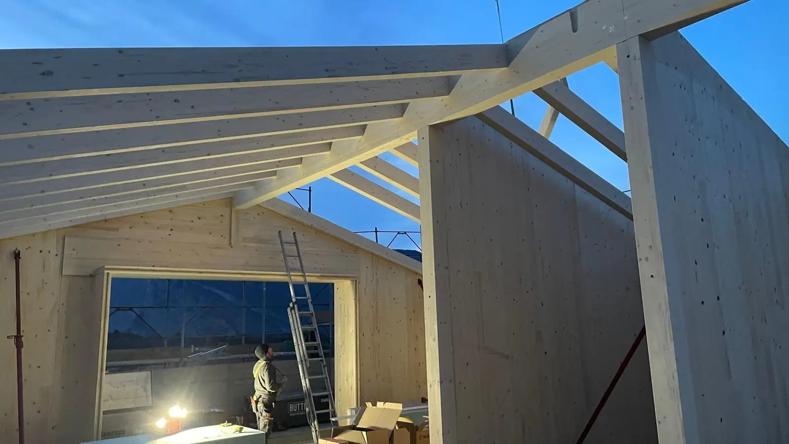 Struttura del tetto in legno lamellare montata al tramonto in un cantiere