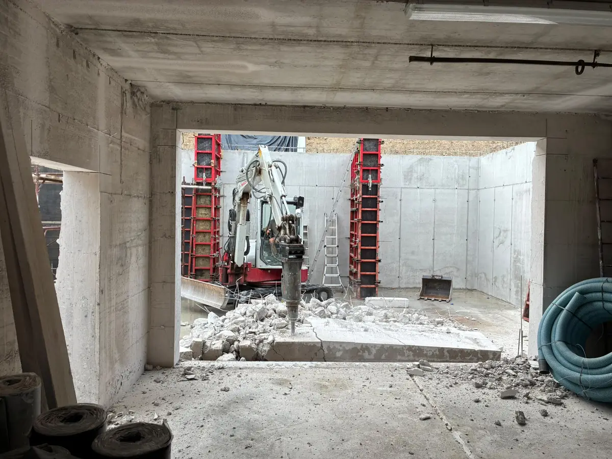 Demolitore radiocomandato al lavoro in un locale in calcestruzzo