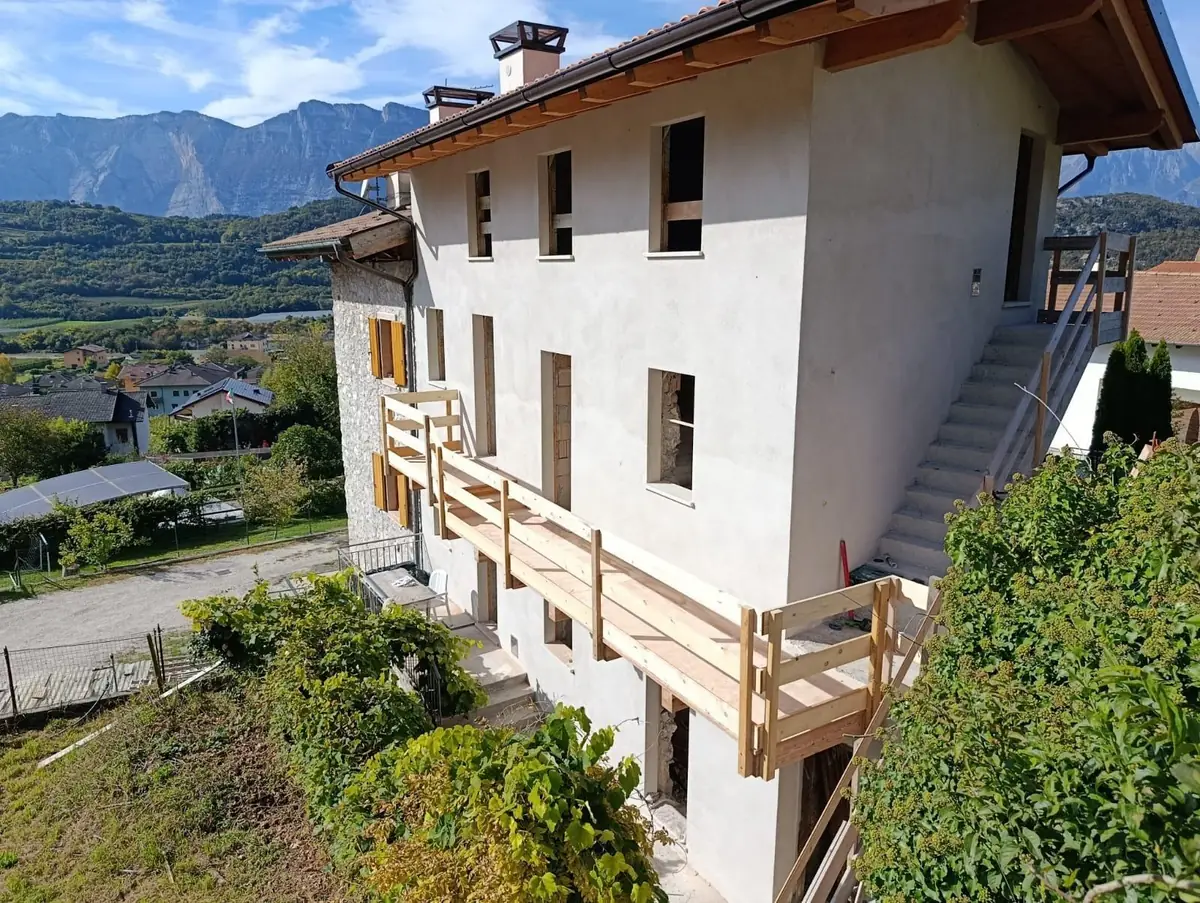 Casa ristrutturata su più livelli con scala esterna in legno