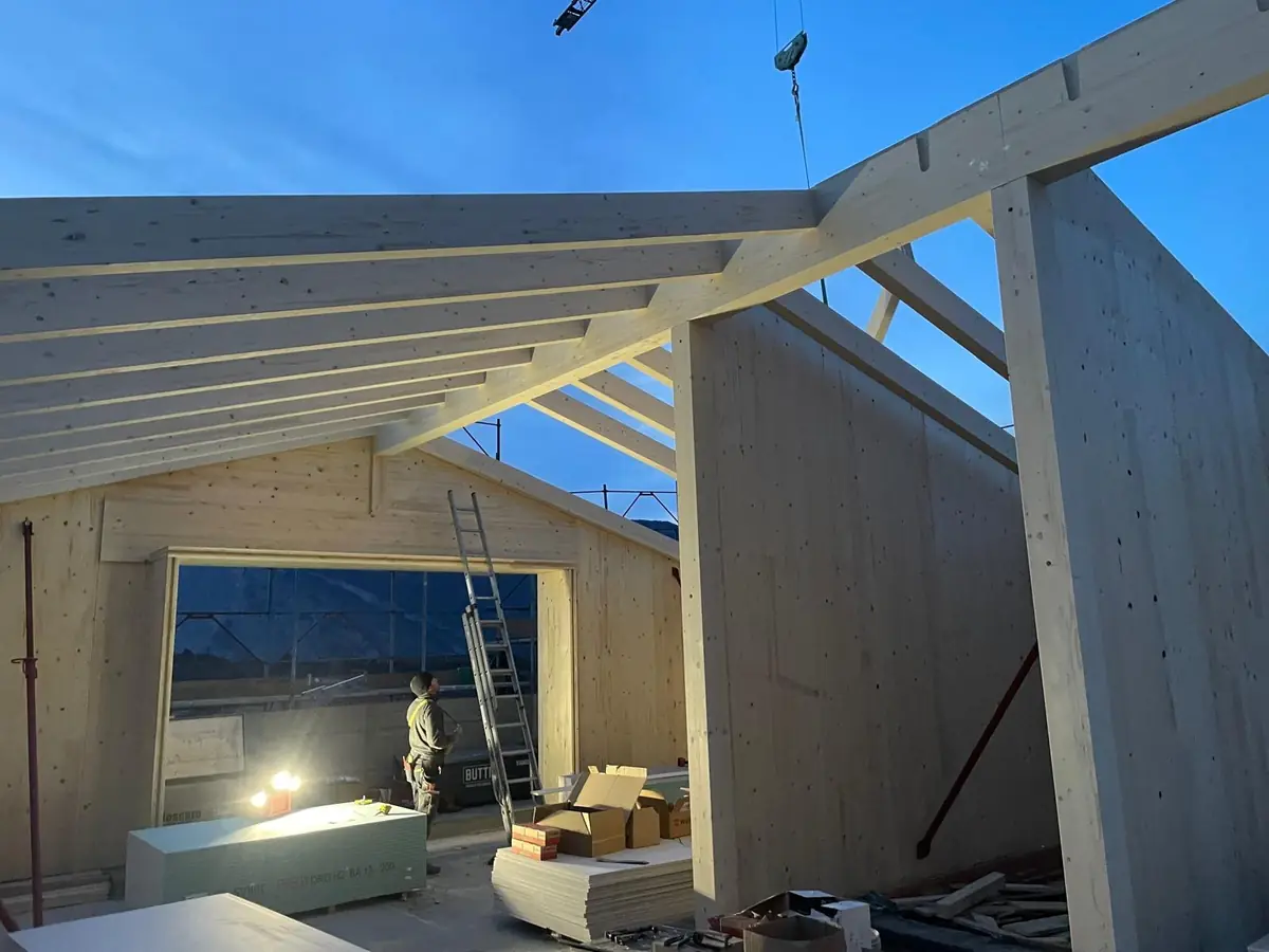 Casa in legno X-lam in costruzione con travi del tetto al tramonto