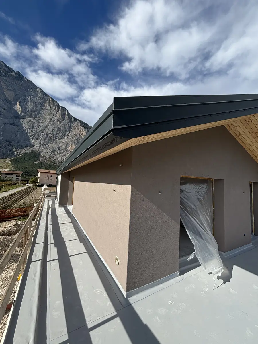 Terrazzo e gronda in larice con la parete di roccia