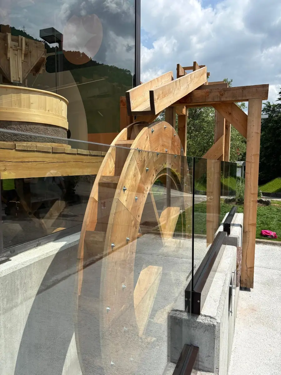 Ruota di mulino in legno dietro una balaustra in vetro